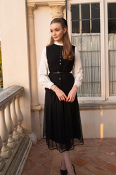 a lady in a white shirt and a black mesh dress with a belt